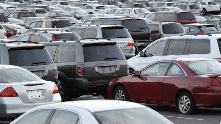 A crowded parking lot filled with various makes and models of cars, suggesting a large-scale vehicle auction.