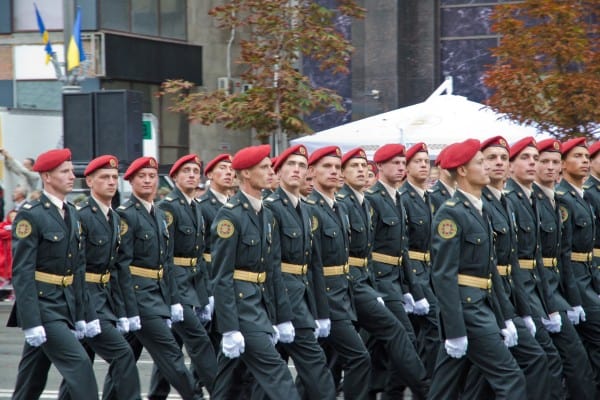 Military cadets marching in formation wearing red berets