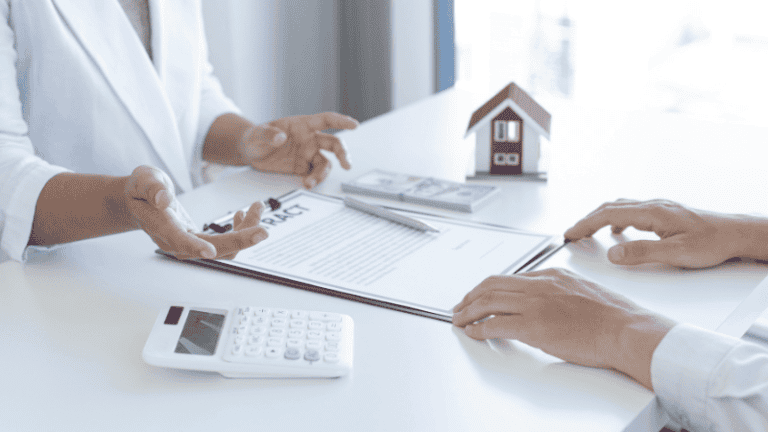 A landlord discussing a house rental or purchase contract with a tenant or buyer at a desk, featuring a small house model, calculator, and documents.