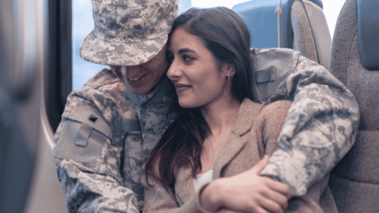 A military soldier in uniform affectionately embracing his spouse while sitting together.