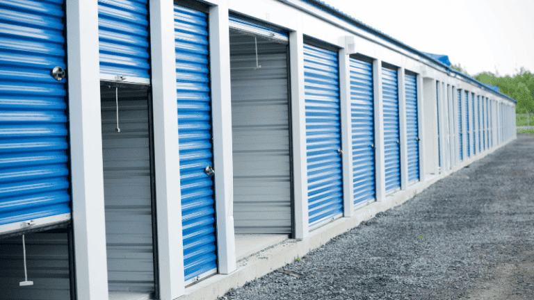 A row of blue and grey storage units, some with open doors, ready to house renters' belongings.
