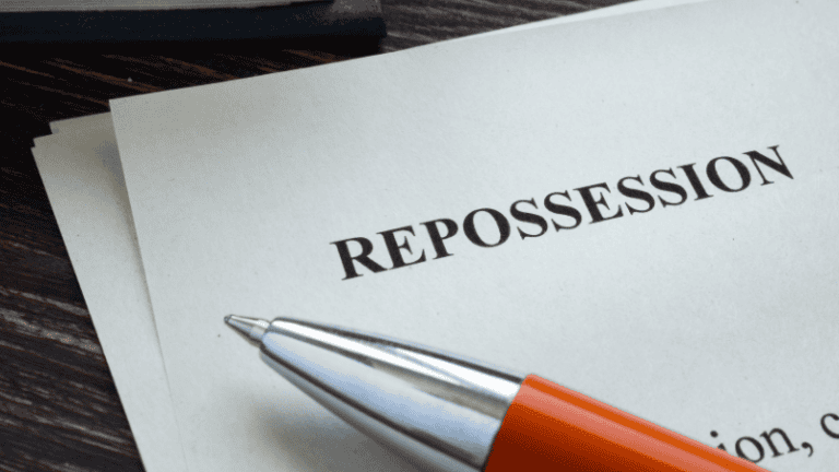A document titled "Repossession" with an orange pen resting on it, symbolizing legal or financial proceedings related to asset recovery.