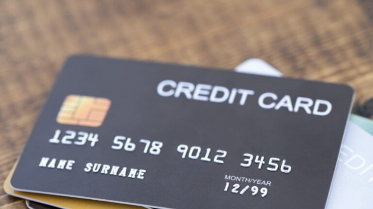 Close-up of a black credit card with chip and placeholder details.
