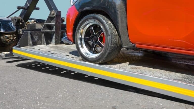 Car being loaded onto flatbed tow truck for transport