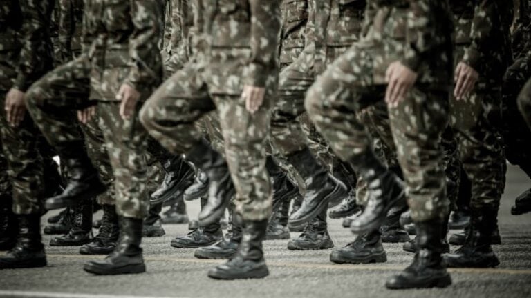 Soldiers marching in camouflage uniforms during a parade.