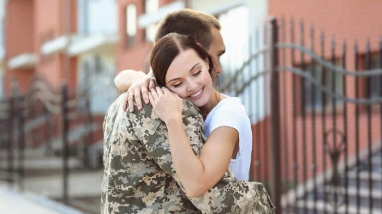Military spouse hugging soldier outdoors