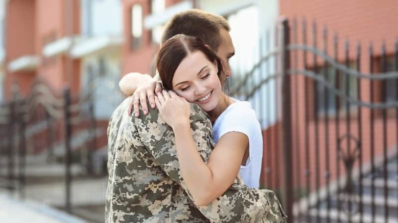 Military spouse hugging soldier outdoors