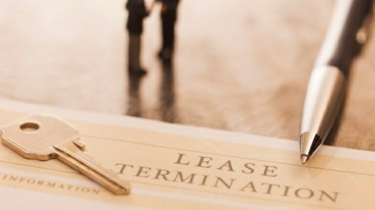 Lease termination document with key and pen on table.