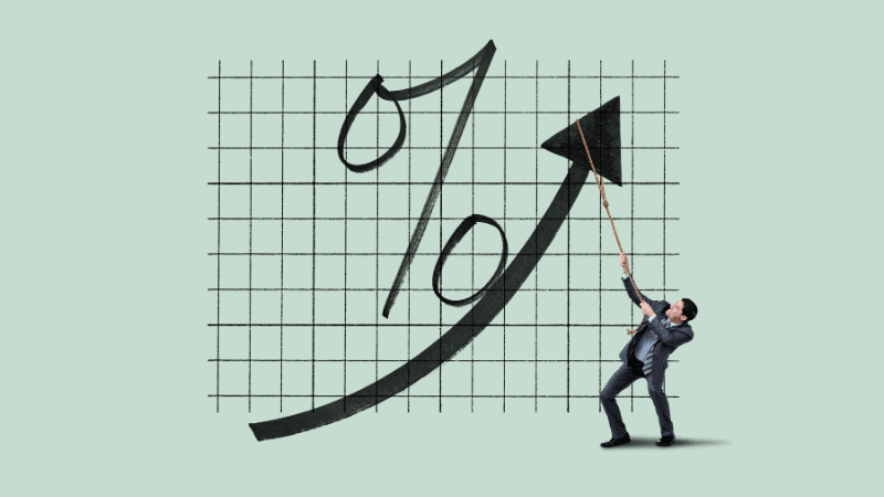 A businessman pulling an upward arrow on a percentage chart, representing rising interest rates or financial growth.