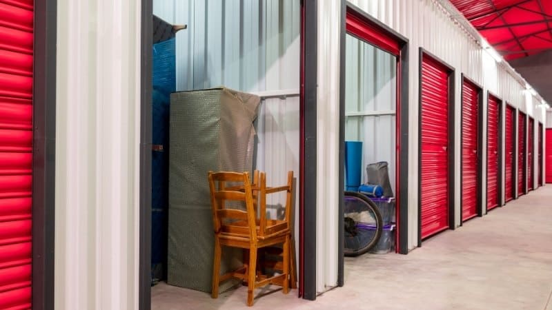 Furniture and items stored inside red self-storage units.