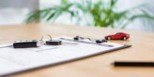 Vehicle title paperwork and car keys on document for abandoned vehicle title process