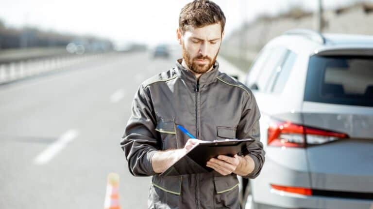 Man documenting a vehicle on roadside while reporting abandoned car for legal title process