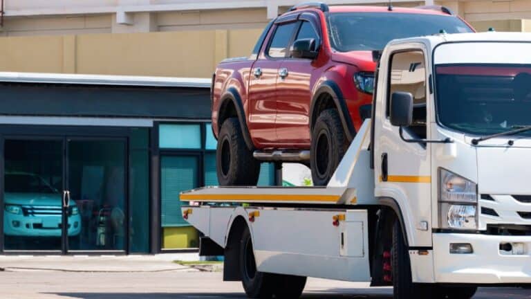 Tow truck transporting a vehicle to a vehicle storage facility