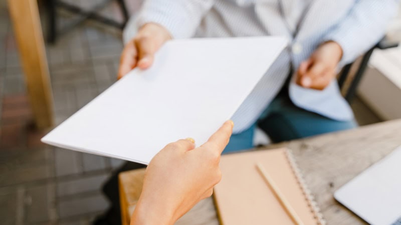 Person handing over official notice document related to vehicle storage