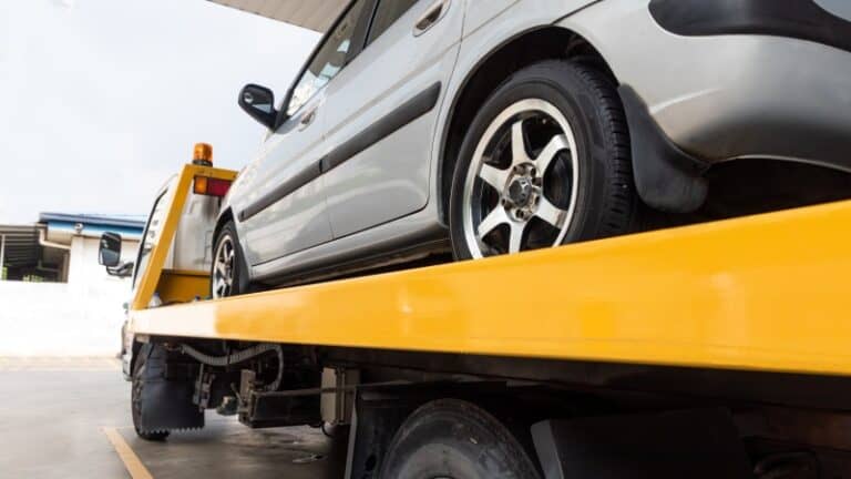 Tow truck loading a vehicle during tow lot lien sale enforcement process
