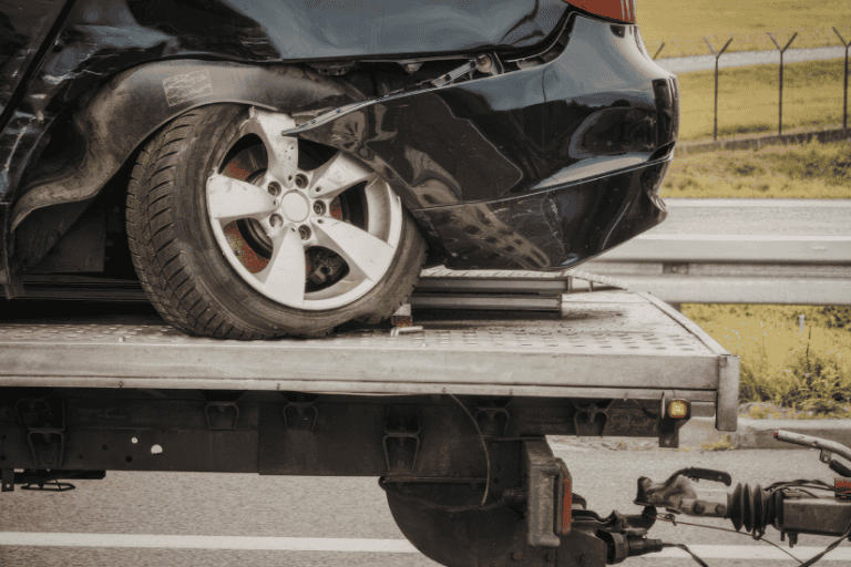 damaged car on top of a towing truck